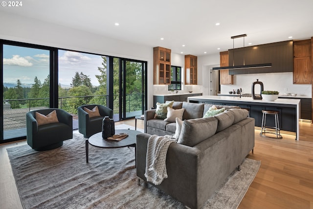 living area with light wood-style flooring and recessed lighting