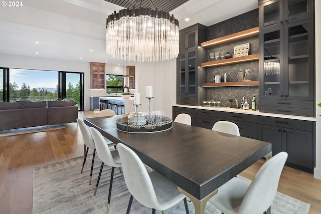 dining space featuring recessed lighting, a notable chandelier, and light wood finished floors