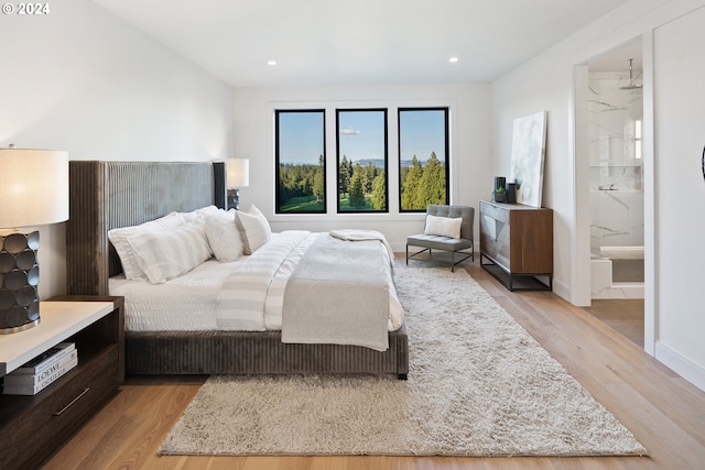 bedroom with baseboards, wood finished floors, and recessed lighting