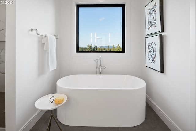 bathroom featuring a soaking tub and baseboards
