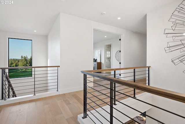 hallway with wood finished floors, an upstairs landing, and recessed lighting