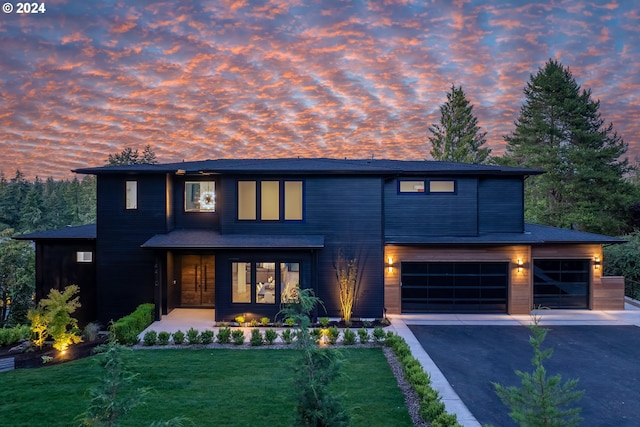 contemporary house with a garage, driveway, and a front lawn