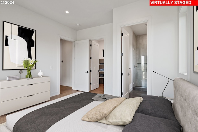 bedroom with connected bathroom and hardwood / wood-style floors