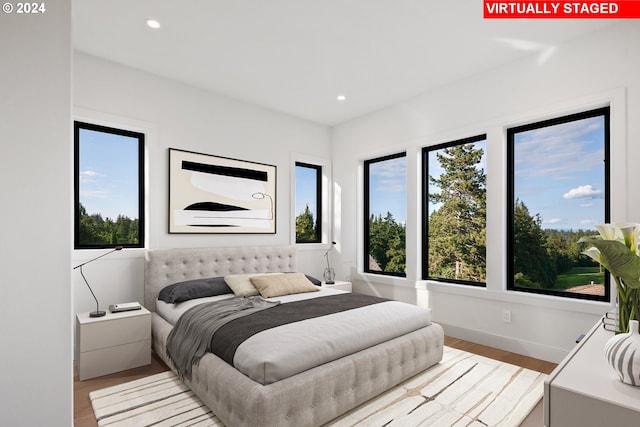 bedroom with baseboards, wood finished floors, and recessed lighting
