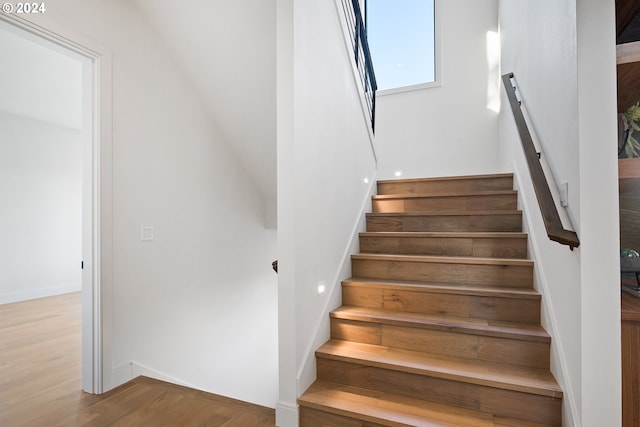 stairs featuring hardwood / wood-style floors