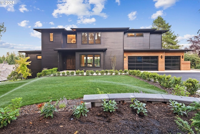 contemporary house featuring a front yard and a garage