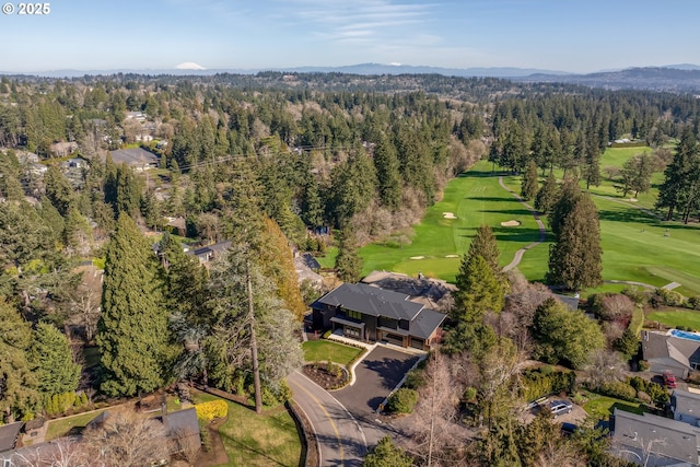 bird's eye view with view of golf course and a view of trees