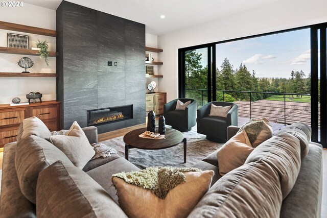 living room featuring a tiled fireplace, a wealth of natural light, and light wood-type flooring