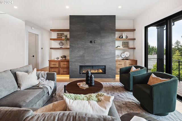 living area featuring wood finished floors, a tiled fireplace, and recessed lighting