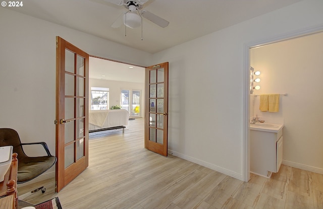 hall with french doors, light hardwood / wood-style flooring, and sink