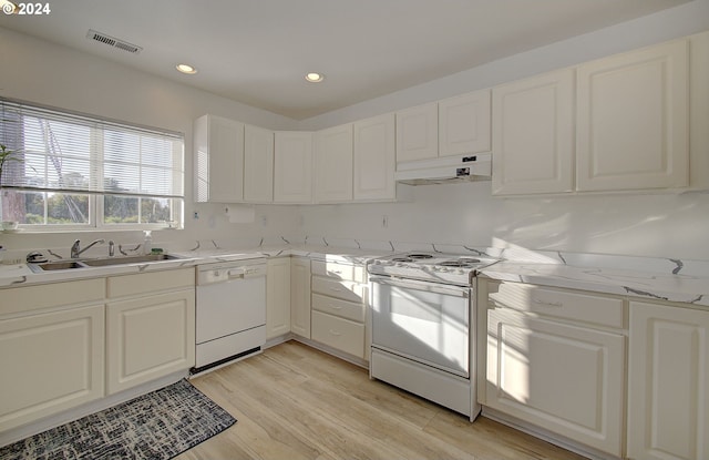 kitchen featuring white cabinets, sink, white appliances, light hardwood / wood-style flooring, and light stone countertops