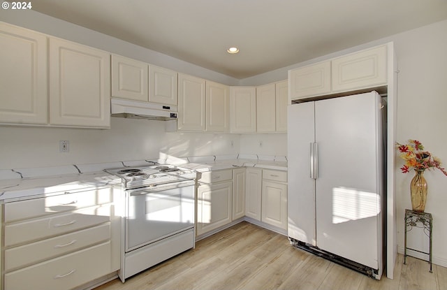 kitchen with light stone countertops, light wood-type flooring, white appliances, and white cabinetry