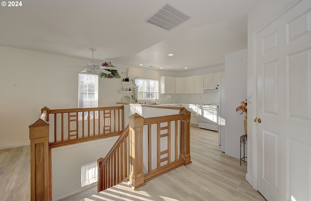 stairs with ceiling fan and hardwood / wood-style floors