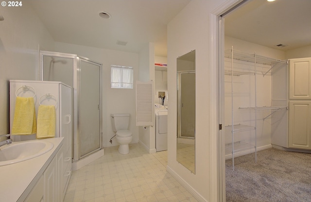 bathroom with walk in shower, washer / dryer, vanity, and toilet