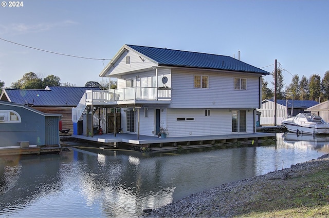 rear view of house featuring a deck with water view