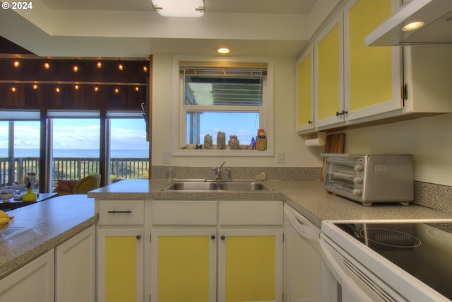 kitchen with white appliances, exhaust hood, sink, white cabinetry, and kitchen peninsula