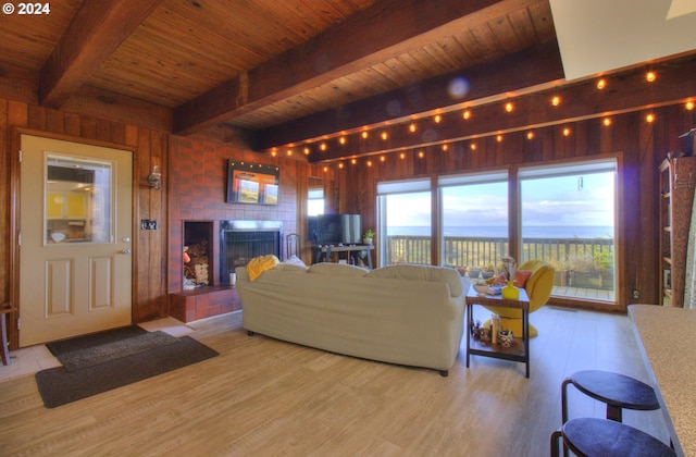 living room with wood walls, a fireplace, wooden ceiling, and light hardwood / wood-style floors