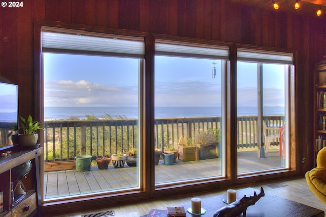 doorway to outside with a water view and wooden walls