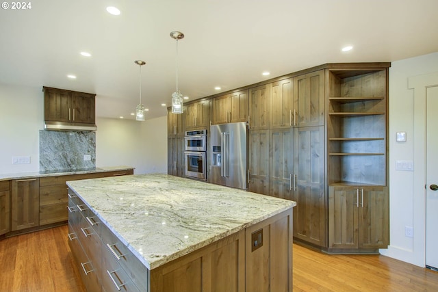 kitchen featuring a kitchen island, stainless steel appliances, backsplash, light stone counters, and light hardwood / wood-style flooring