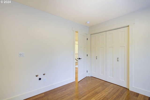 unfurnished bedroom featuring wood-type flooring and a closet