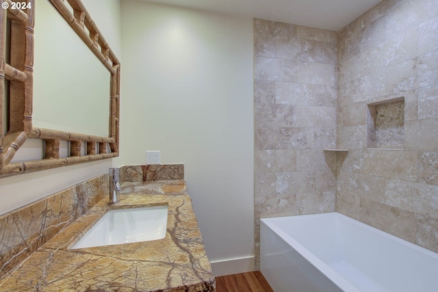 bathroom featuring vanity, wood-type flooring, and a bathing tub