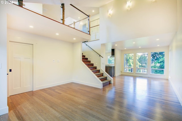 unfurnished living room featuring a high ceiling and wood-type flooring