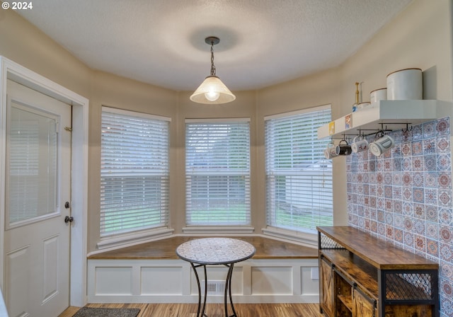 dining area featuring a textured ceiling and light hardwood / wood-style flooring