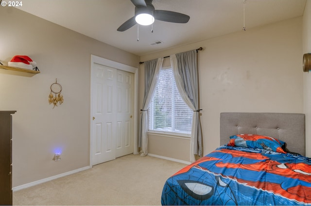 carpeted bedroom featuring ceiling fan and a closet