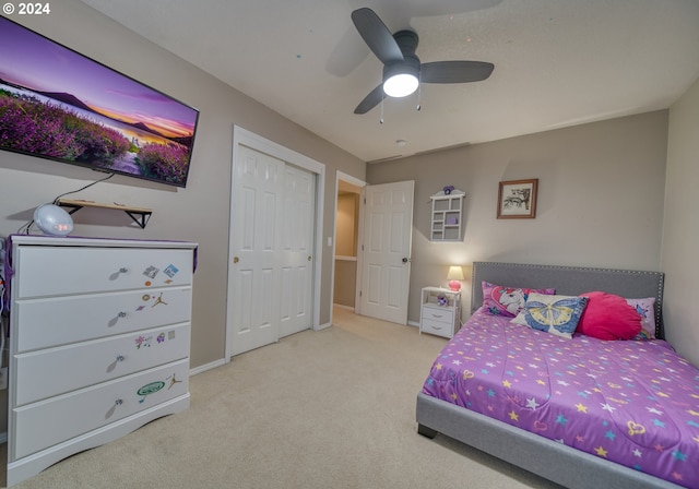 bedroom with light colored carpet, a closet, and ceiling fan