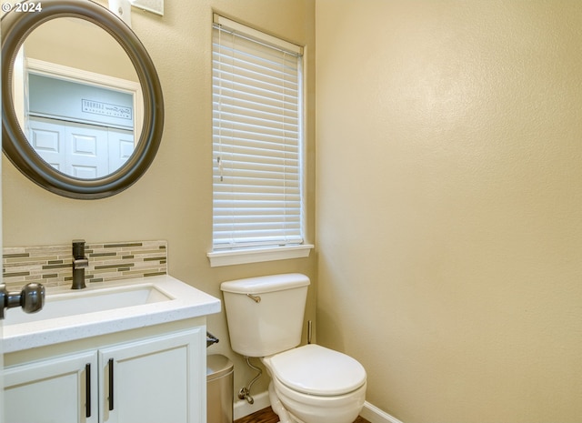 bathroom with decorative backsplash, vanity, and toilet