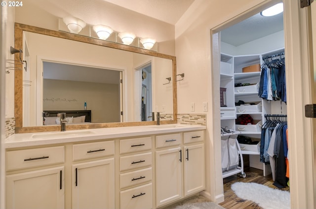 bathroom with hardwood / wood-style floors, vanity, a textured ceiling, and lofted ceiling