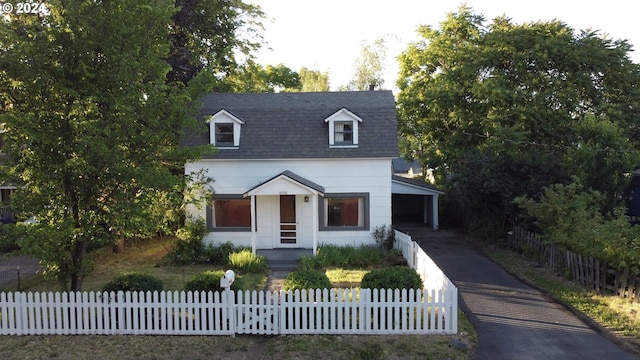 cape cod-style house featuring a carport