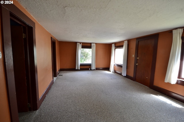 carpeted spare room with a textured ceiling