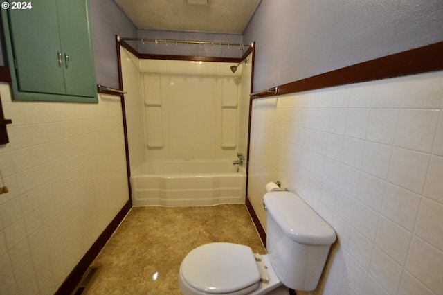 bathroom with toilet, tub / shower combination, and tile walls