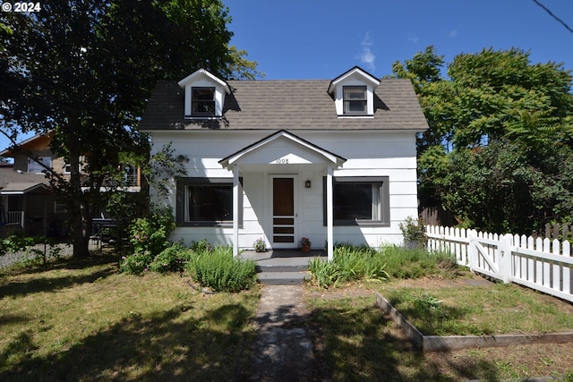 cape cod house featuring a front lawn