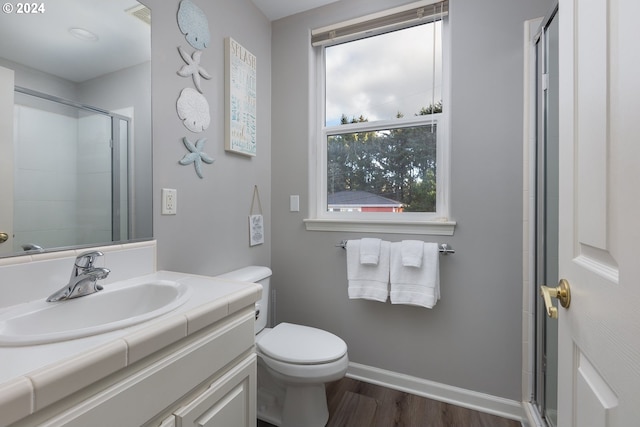 bathroom featuring toilet, an enclosed shower, wood-type flooring, and a healthy amount of sunlight