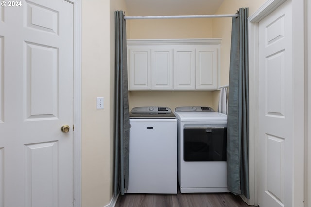 laundry room featuring washer and dryer, dark hardwood / wood-style flooring, and cabinets