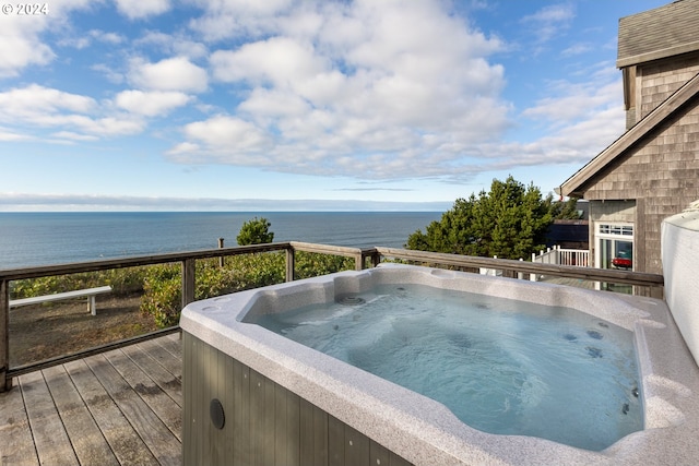 view of swimming pool featuring a deck with water view and a hot tub