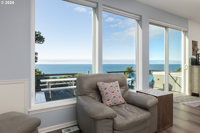 interior space with hardwood / wood-style floors and a water view