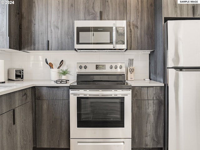 kitchen with backsplash, dark brown cabinets, and stainless steel appliances