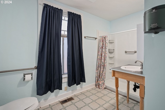 bathroom featuring a shower with shower curtain, sink, and toilet