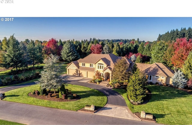 view of front of property with a garage and a front lawn