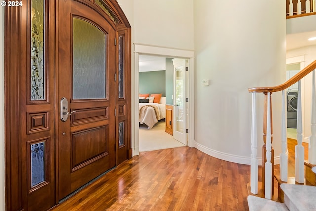 foyer entrance with washer / dryer and hardwood / wood-style floors