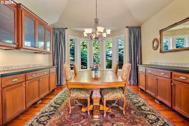 dining space featuring lofted ceiling, dark hardwood / wood-style floors, and a notable chandelier