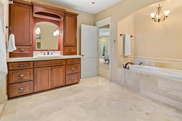 bathroom with an inviting chandelier, tiled tub, and vanity