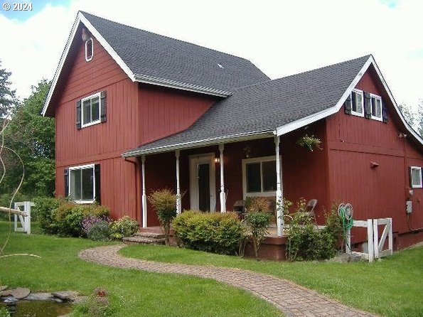 rear view of property featuring covered porch and a lawn