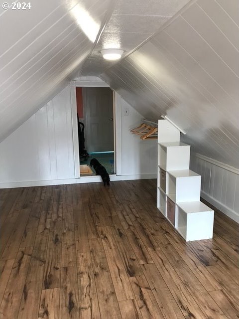 bonus room with vaulted ceiling and dark hardwood / wood-style floors