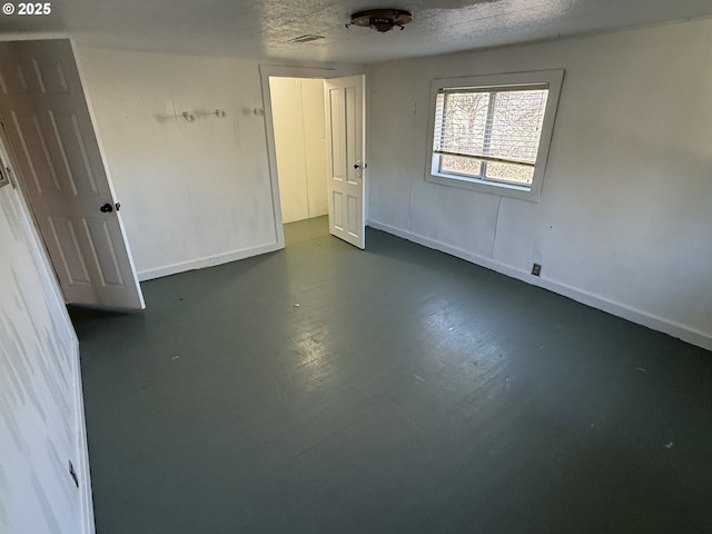 unfurnished room with a textured ceiling