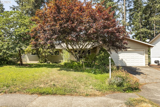 obstructed view of property featuring a garage and a front yard