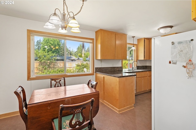 kitchen featuring white fridge, a chandelier, dark colored carpet, hanging light fixtures, and sink